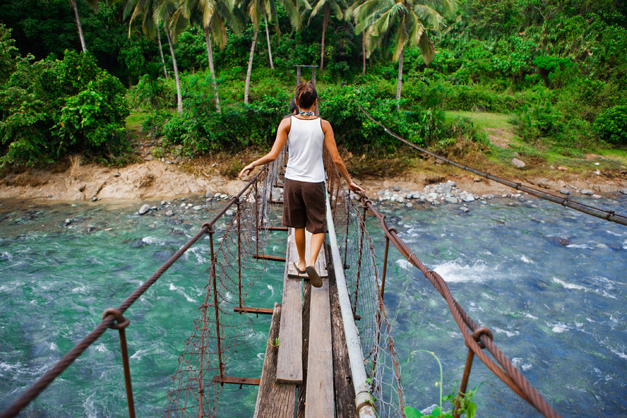 Monica crossing a hanging bridge near Adams, Laoag